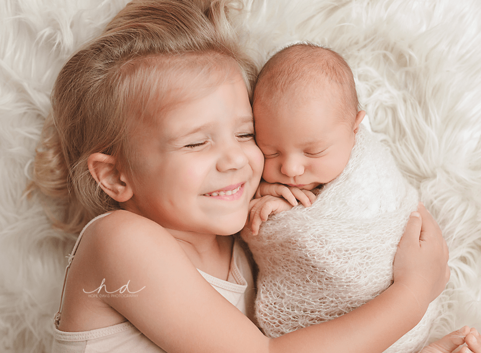 newborn sibling photography pose
