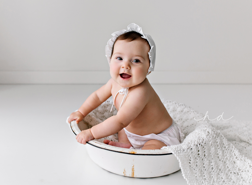 baby girl in a wash tub with bonnet
