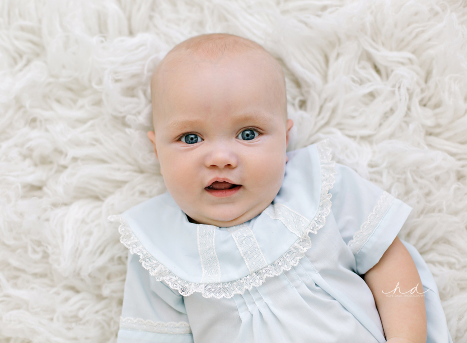 Baby boy laying on a white flokati