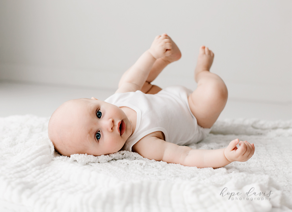 best baby photographer in mississippi baby laying on floor white studio hope davis
