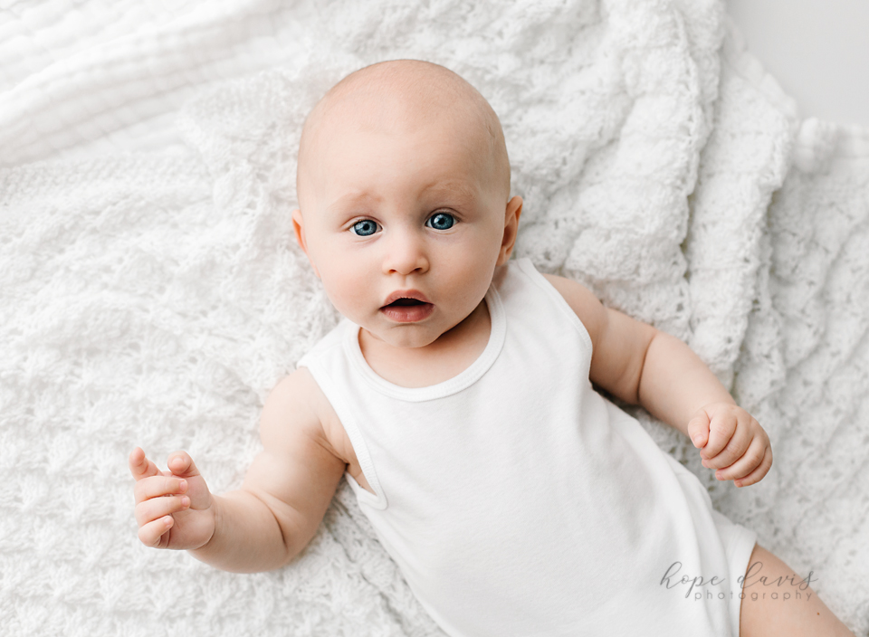 brandon mississippi baby photography baby on white blanket in white onesie