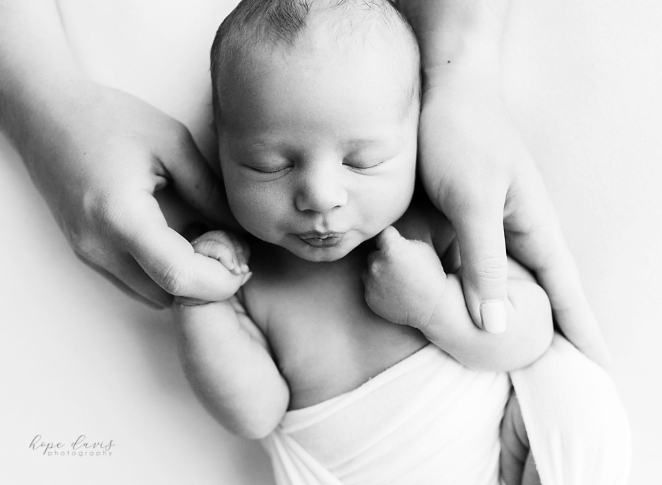 central mississippi newborn photographer baby holding moms hands black and white hope davis