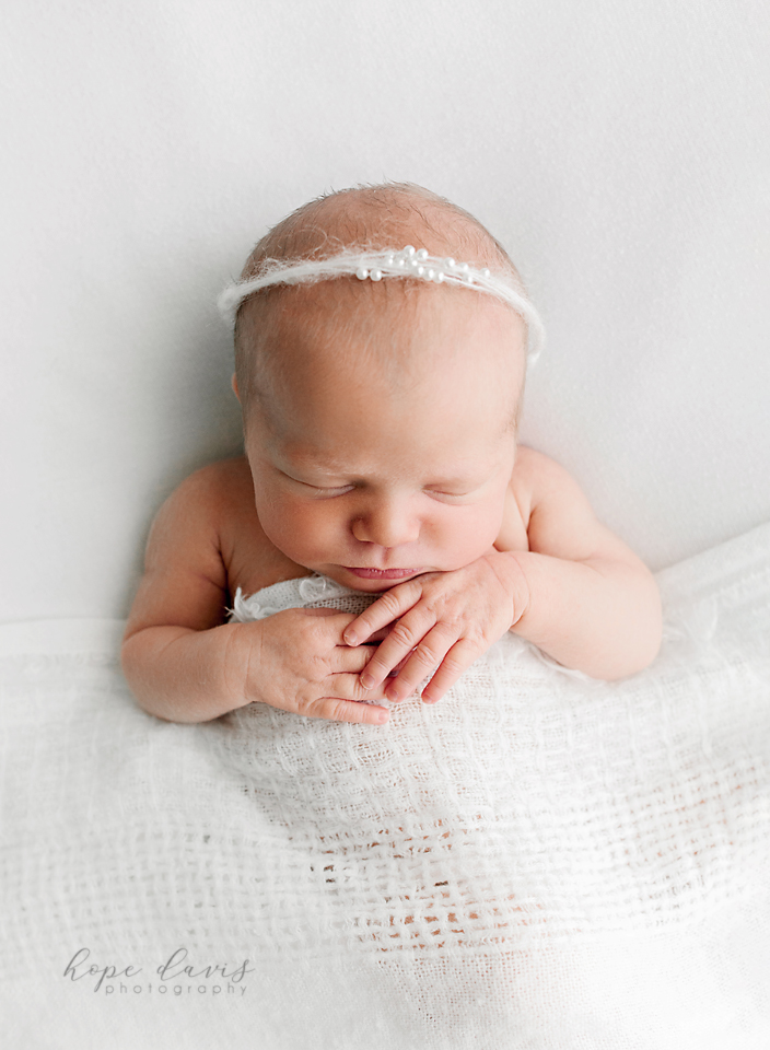 brandon ms newborn photographer baby with white blanket and pearls