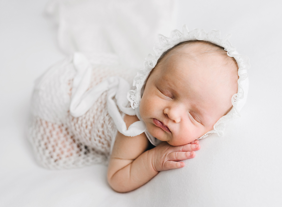 meridian ms baby photography newborn girl with bonnet laying on tummy