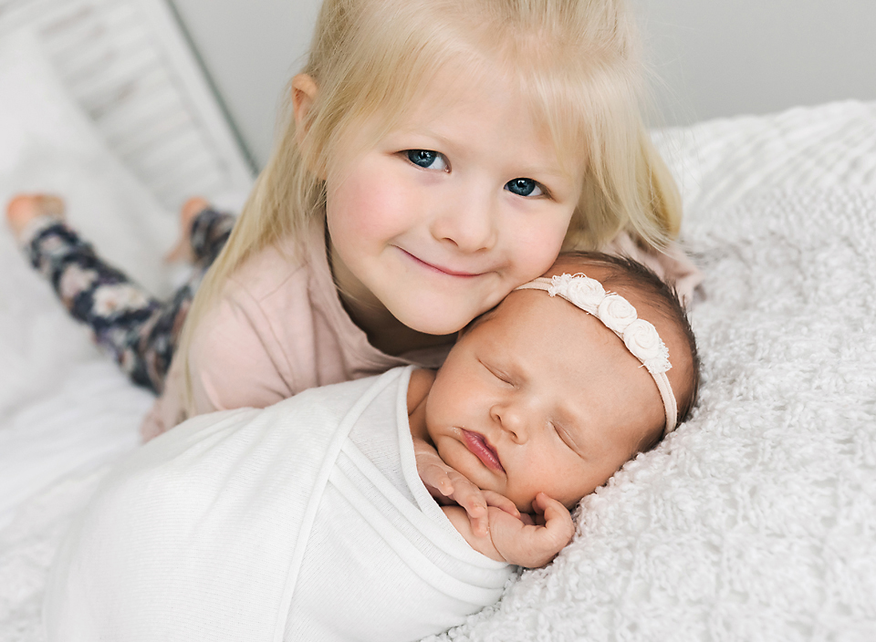 meridian ms family photographer newborn and sister on bed
