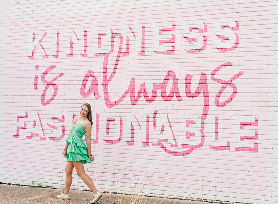 Meridian Mississippi senior photo session girl in green dress walking on sidewalk in front of mural