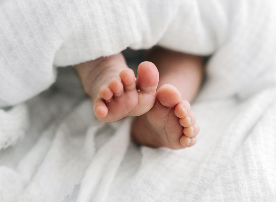 newborn toes on white blanket