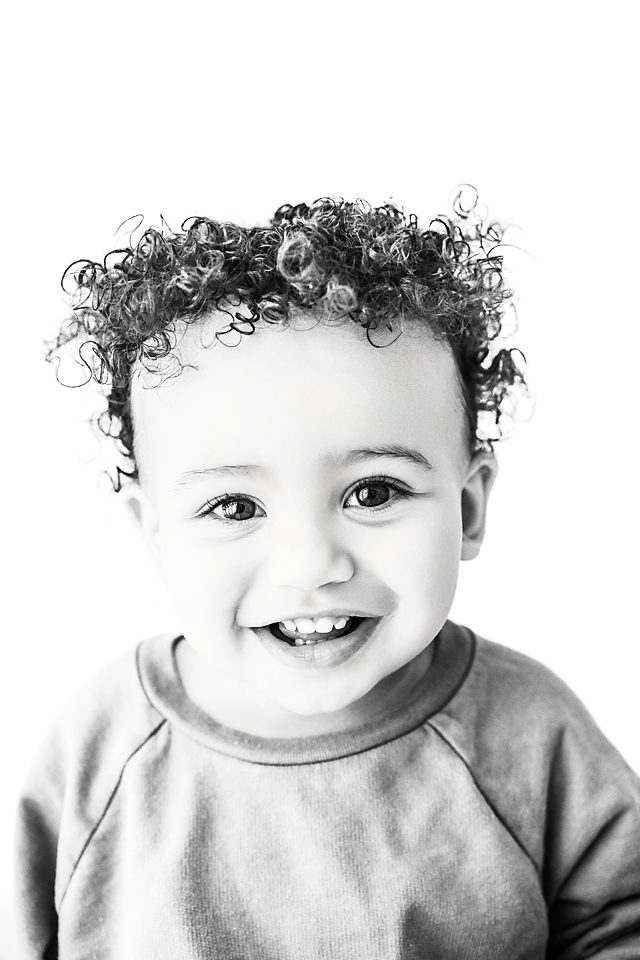 Close-up of toddler boy with big brown eyes looking directly at the camera during black and white Little Faces session in Decatur, MS