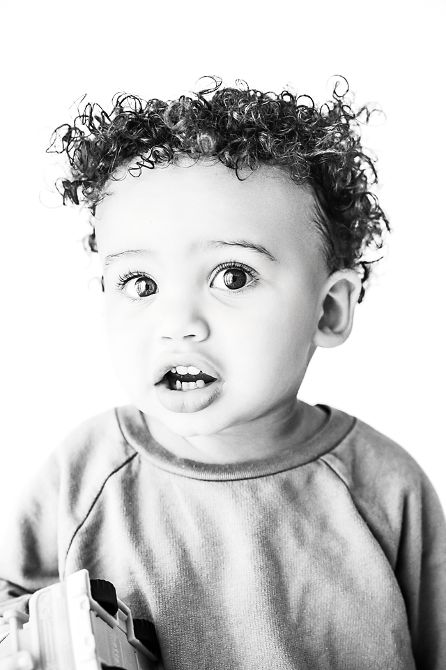 Black and white portrait of Cruz, age one, showing a curious expression at Hope Davis Photography studio